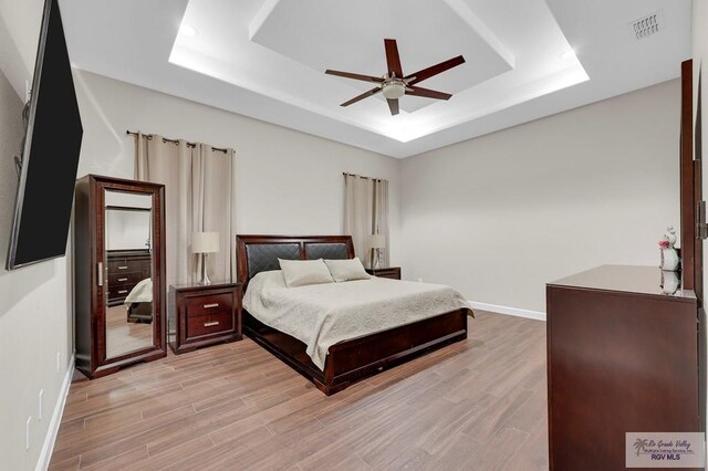 5706 Spicewood, Harlingen, TX 78552 - bedroom featuring a tray ceiling, light wood finished floors, and a ceiling fan