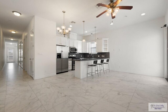 110 E Retama St, South Padre Island, TX 78597 - kitchen featuring appliances with stainless steel finishes, a kitchen breakfast bar, light marble finish flooring, open shelves, and dark countertops