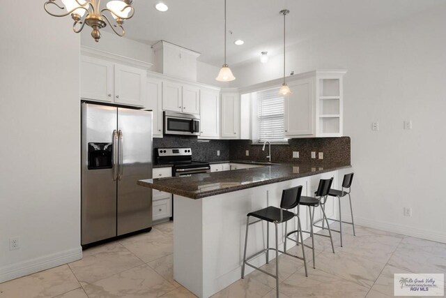 110 E Retama St, South Padre Island, TX 78597 - kitchen featuring stainless steel appliances, light marble finish floors, a peninsula, white cabinets, and recessed lighting