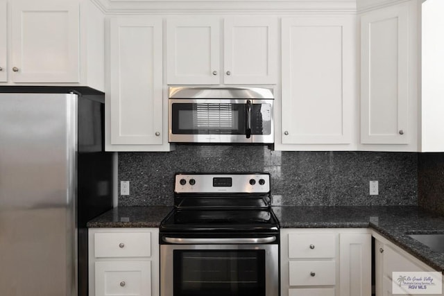 110 E Retama St, South Padre Island, TX 78597 - kitchen featuring stainless steel appliances, white cabinets, tasteful backsplash, and dark stone counters