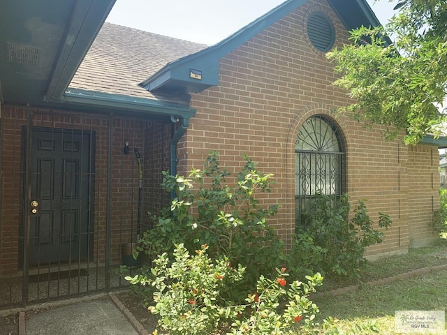 35 Yucatan Ct, Brownsville, TX 78526 - view of side of home with brick siding and roof with shingles