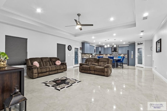 living room featuring baseboards, recessed lighting, a raised ceiling, and crown molding