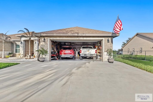 view of front facade featuring driveway, roof with shingles, an attached garage, and fence