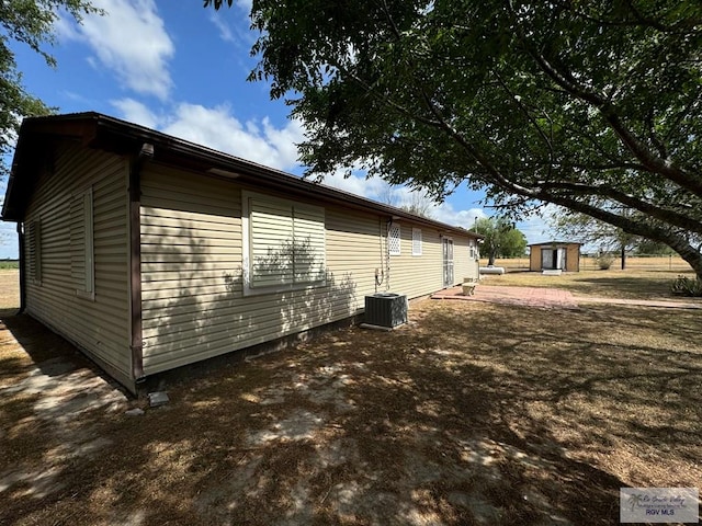 view of home's exterior with a storage shed and central air condition unit