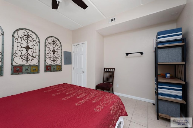 bedroom featuring ceiling fan, light tile patterned floors, and electric panel