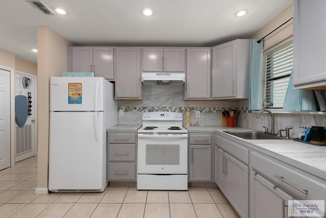 kitchen featuring white appliances, tasteful backsplash, light tile patterned flooring, and sink