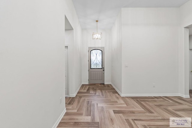 foyer entrance featuring an inviting chandelier and light parquet floors