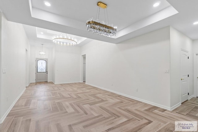 interior space with light parquet flooring and a tray ceiling