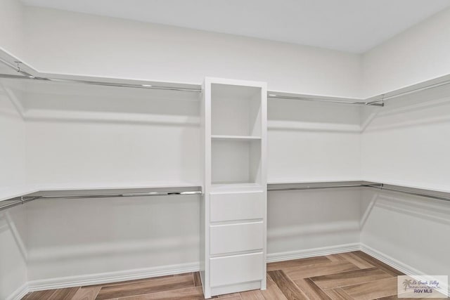 spacious closet featuring parquet floors