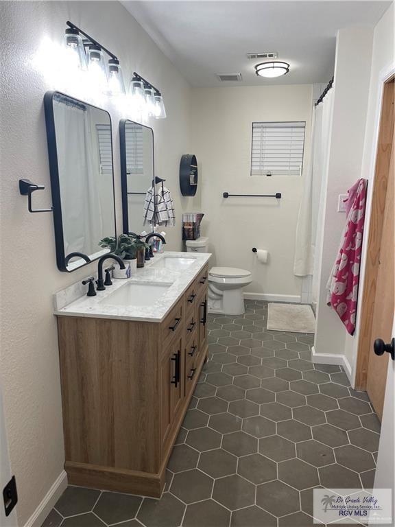 bathroom featuring tile patterned floors, vanity, and toilet