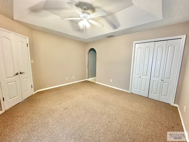 114 Willow Cir, Harlingen, TX 78552 - unfurnished bedroom featuring a textured ceiling, carpet floors, baseboards, a ceiling fan, and arched walkways