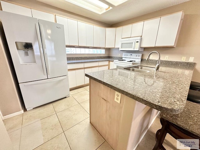 114 Willow Cir, Harlingen, TX 78552 - kitchen featuring white appliances, a peninsula, a sink, dark stone countertops, and white cabinetry