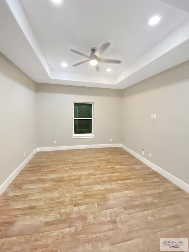 empty room featuring a raised ceiling, ceiling fan, and recessed lighting