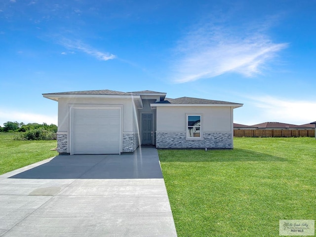 prairie-style home featuring concrete driveway, stucco siding, stone siding, and a front lawn