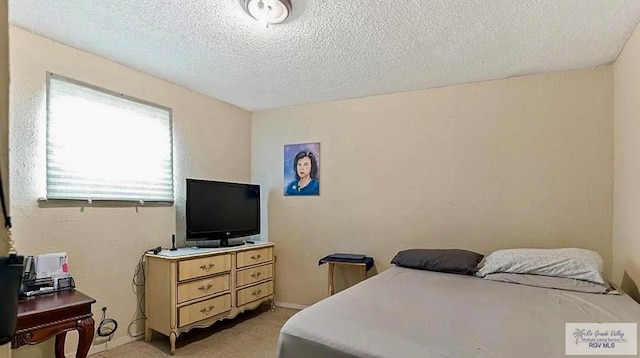 carpeted bedroom with a textured ceiling