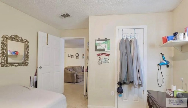 carpeted bedroom featuring a textured ceiling