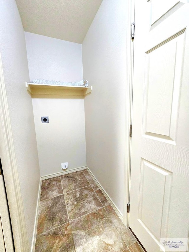 washroom with baseboards, hookup for an electric dryer, and laundry area