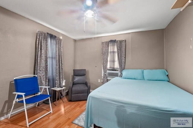 bedroom featuring ceiling fan, hardwood / wood-style floors, and cooling unit