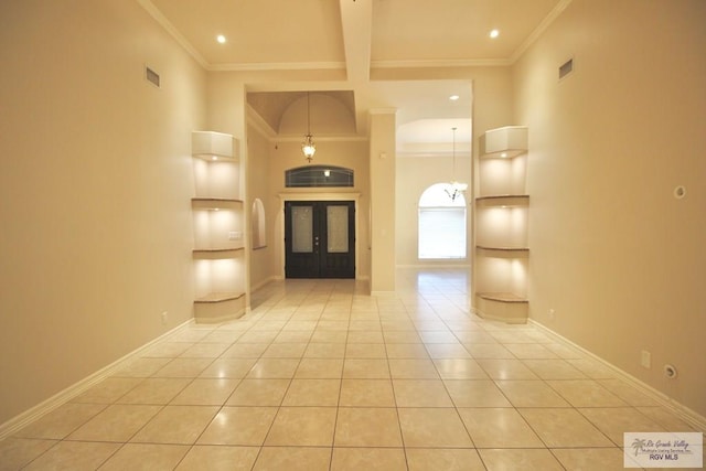 hall with french doors, crown molding, and light tile patterned flooring