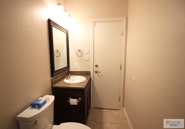 bathroom featuring tile patterned flooring, vanity, and toilet