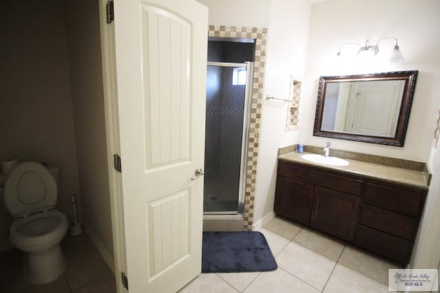 bathroom featuring vanity, toilet, tile patterned flooring, and walk in shower