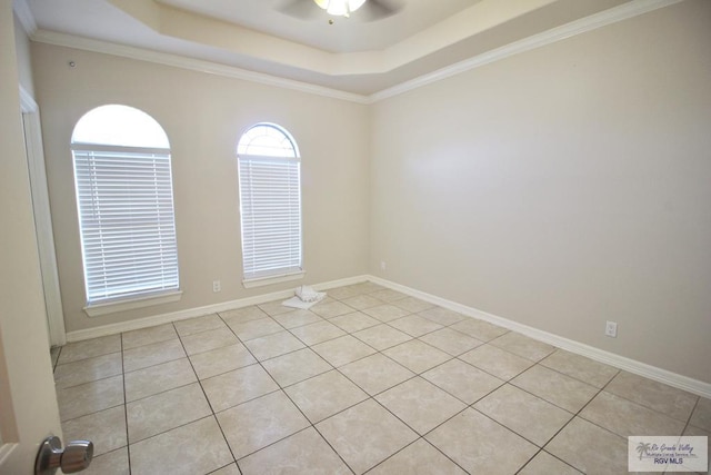tiled empty room featuring ceiling fan, a raised ceiling, and ornamental molding