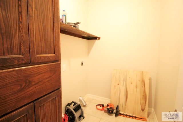 laundry area with hookup for an electric dryer and light tile patterned flooring
