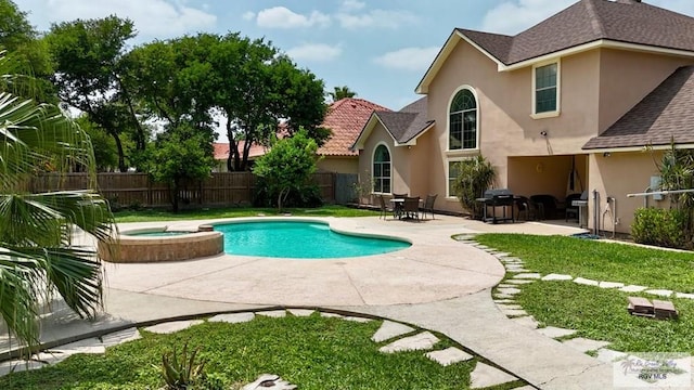 view of pool featuring a patio, a pool with connected hot tub, and fence