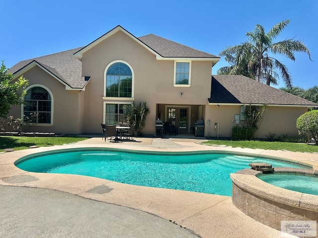 view of pool with french doors, a pool with connected hot tub, a patio, and area for grilling