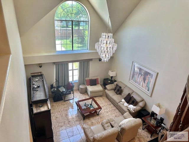 living area featuring high vaulted ceiling and a notable chandelier