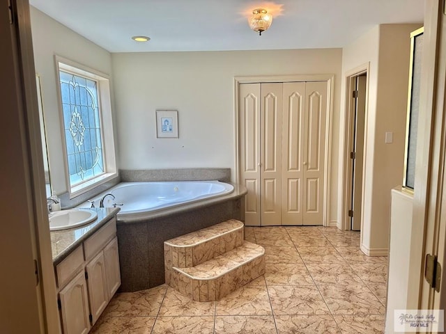 full bath featuring a garden tub and vanity