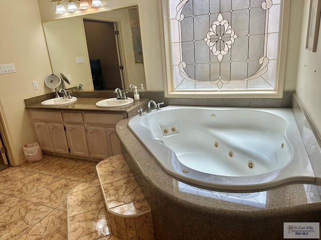 bathroom with double vanity, a sink, and a whirlpool tub