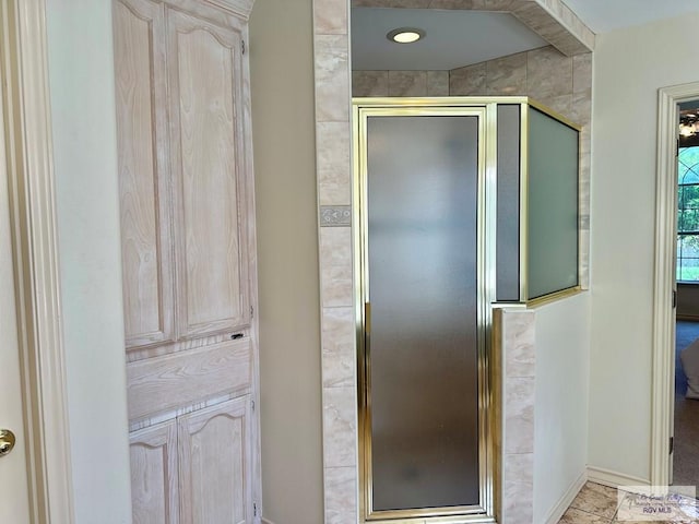 full bath featuring baseboards and a shower stall