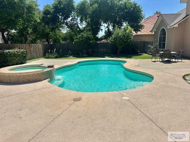 view of pool with a patio area, a fenced backyard, and a pool with connected hot tub