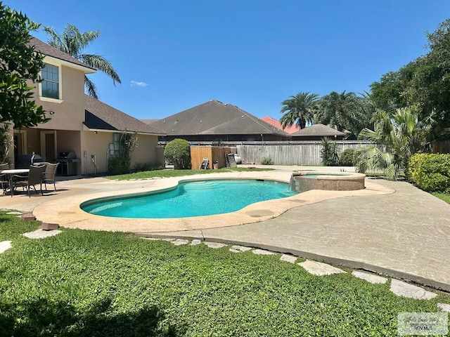 view of swimming pool featuring area for grilling, a pool with connected hot tub, a fenced backyard, a lawn, and a patio area