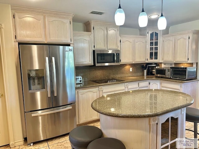 kitchen featuring tasteful backsplash, a breakfast bar area, visible vents, and stainless steel appliances
