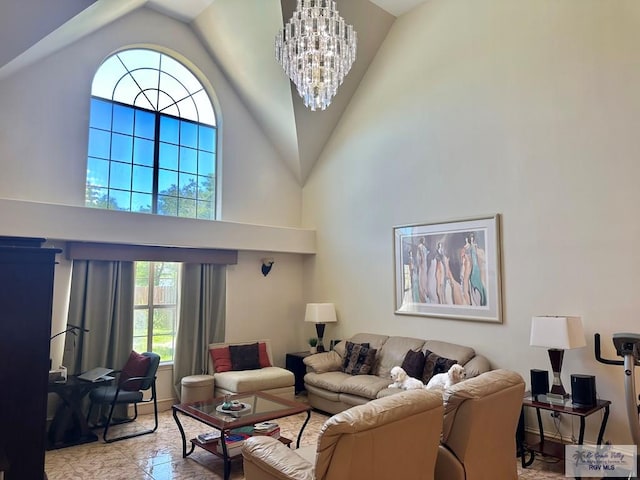 living area with high vaulted ceiling and a notable chandelier