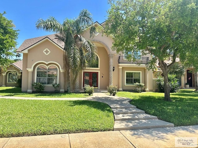 mediterranean / spanish house featuring french doors, a front yard, stucco siding, and a balcony