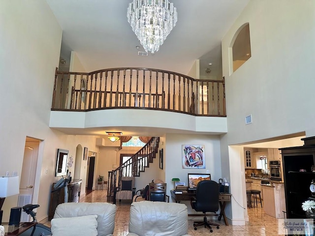 living room with baseboards, arched walkways, a notable chandelier, and stairs