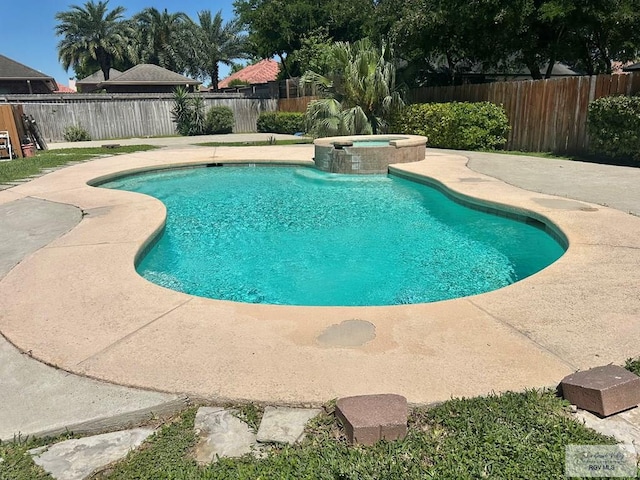 view of swimming pool with a fenced backyard, a pool with connected hot tub, and a patio area