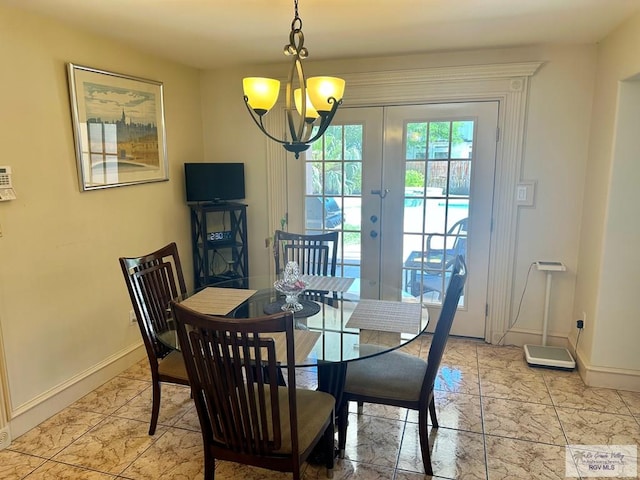 dining area featuring a notable chandelier, baseboards, and french doors