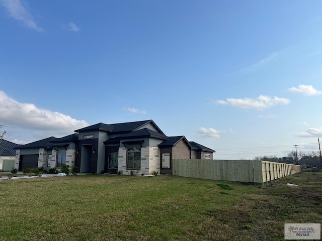 27360 Prudencia St Unit 16, Brownsville, TX 78521 - view of front of house featuring stone siding, a garage, and stucco siding