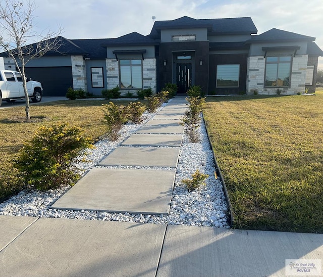 27360 Prudencia St Unit 16, Brownsville, TX 78521 - prairie-style home featuring stone siding, a front yard, and a garage
