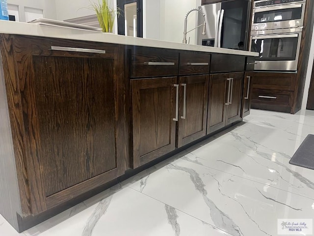 27360 Prudencia St Unit 16, Brownsville, TX 78521 - kitchen with light marble finish flooring, appliances with stainless steel finishes, and dark brown cabinets