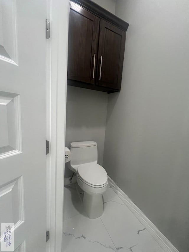 27360 Prudencia St Unit 16, Brownsville, TX 78521 - bathroom with marble look tile flooring, toilet, and baseboards