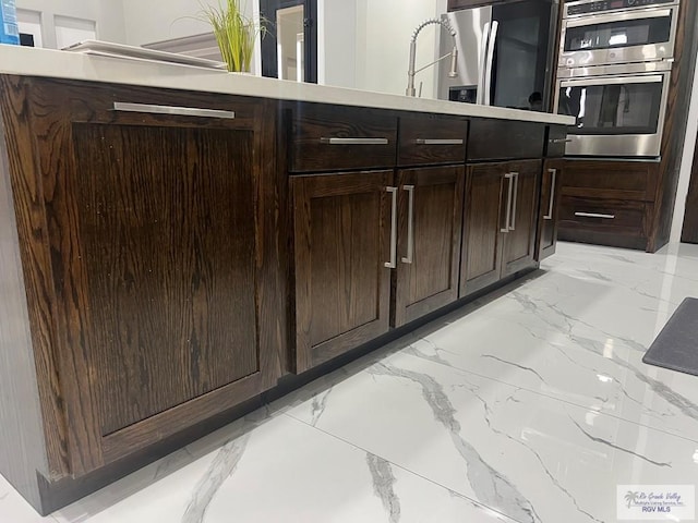 kitchen featuring appliances with stainless steel finishes and dark brown cabinetry