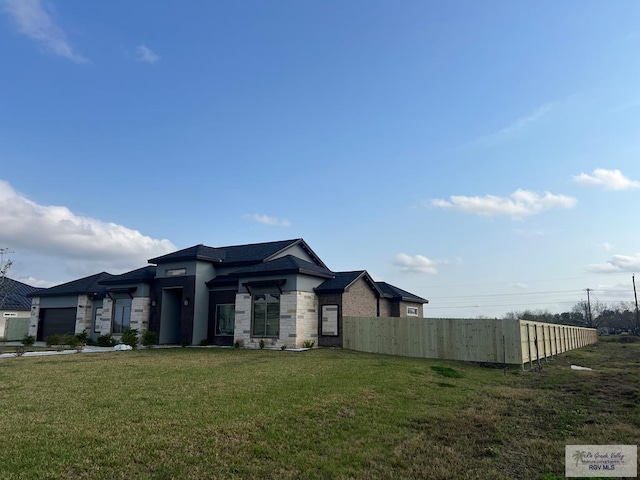 27360 Prudencia St Unit 16, Brownsville, TX 78521 - view of front of house with stone siding, an attached garage, and stucco siding
