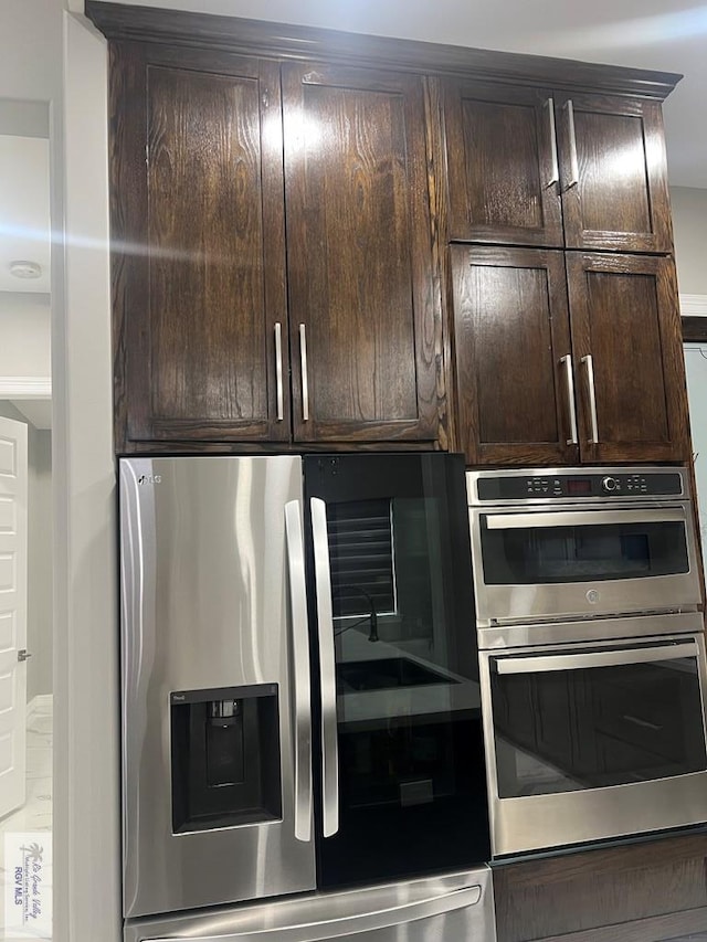 interior space featuring stainless steel appliances and dark brown cabinetry