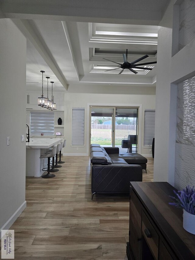 kitchen featuring sink, decorative light fixtures, a notable chandelier, light stone countertops, and white cabinets