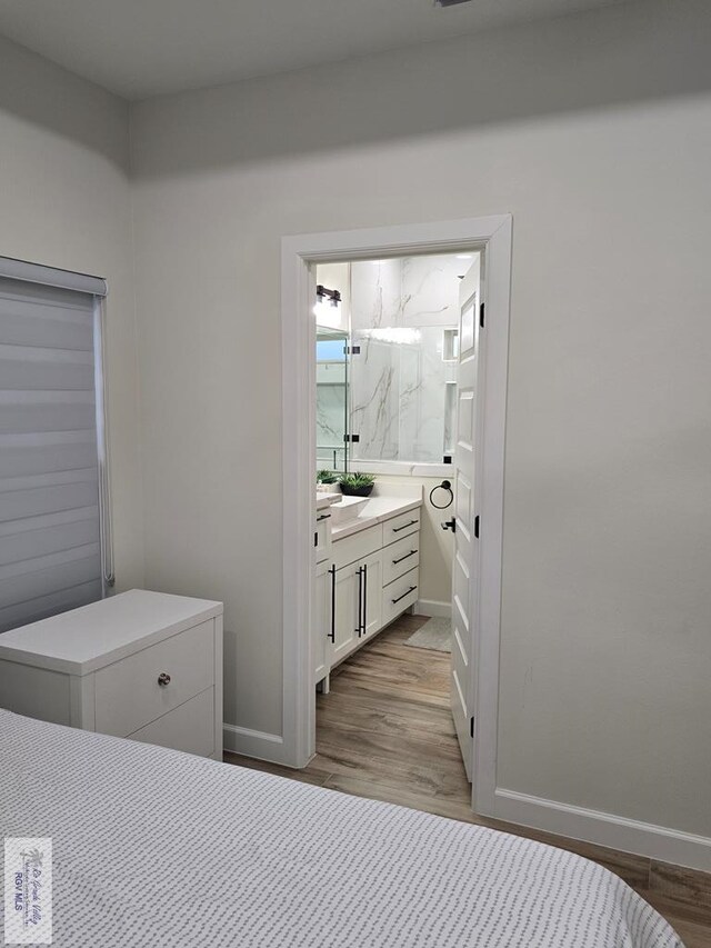 bathroom featuring vanity, a shower with shower door, and wood-type flooring